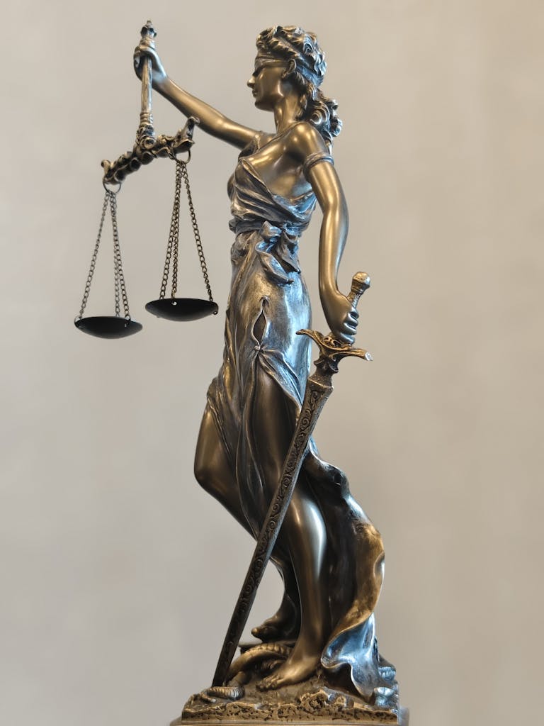 A detailed statue of Lady Justice holding scales and a sword, symbolizing law and fairness.